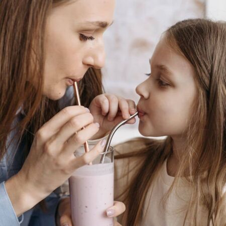 Mutter und Tochter teilen sich ein Getränk